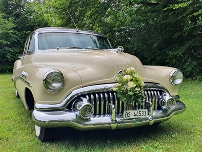 Hochzeitsauto-Vermietung - Der tolle Buick mit Blumenschmuck auf einer Wiese. Mehr braucht's nicht für ein besonderes Bild! - Buick Super Eight