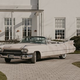 Hochzeitsauto: Diese Bilder entstanden bei einem schönen Shooting mit Flor-Fotografie vorm Strandhotel in Glücksburg  - Traumhaftes Pink Cadillac 1959 Cabrio 