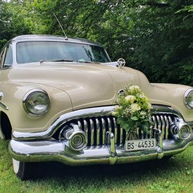 Hochzeitsauto: Der tolle Buick mit Blumenschmuck auf einer Wiese. Mehr braucht's nicht für ein besonderes Bild! - Buick Super Eight